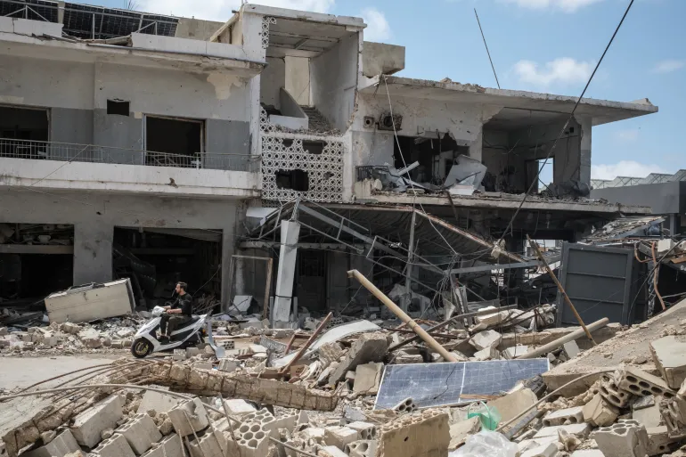 A man rides a scooter past destroyed shops, amid a temporary ceasefire between Lebanon and Israel, in Tyre, southern Lebanon, April 28, 2026. REUTERS/Marko Djurica