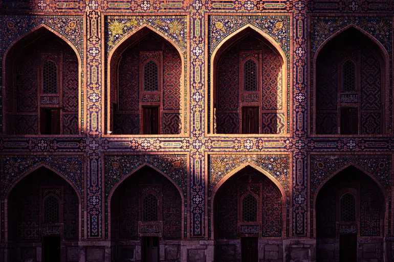 SAMARKAND, UZBEKISTAN: Ornate tiled façade of the famous Silk Roas Islamic Tilya-Kori Madrasa at Registan Square in Samarkand illuminated by sunlight in the late afternoon.; Shutterstock ID 2663512209; purchase_order: aj; job: ; client: ; other:
