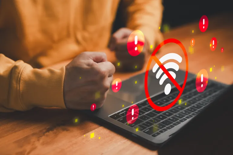 Frustrated user with laptop facing WiFi disconnection, red warning icons and no internet signal error symbol. Concept of network outage, connectivity problem, unstable internet and online frustration.