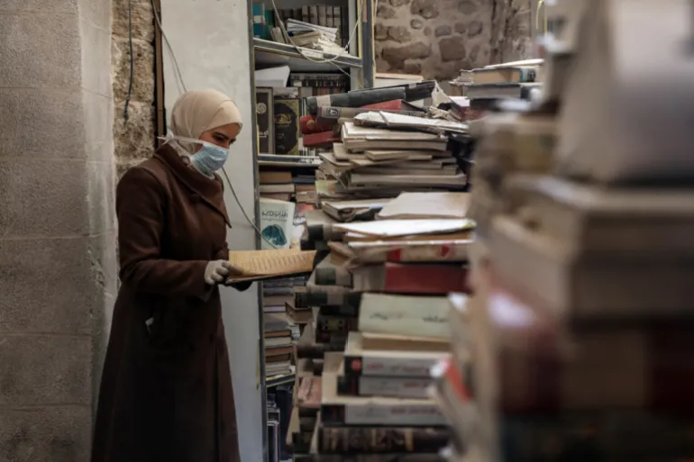 متطوعون يحاولون إنقاذ مكتبة المسجد العمري التاريخية في غزة بعد دمار الحرب. صور: Emad Drimly/dpa