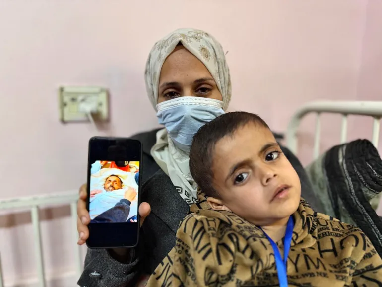 السيدة إيمان أبو جامع التي فقدت زوجها وبكرها موسى بمرض لم يستطع الأطباء تشخيصه وتحمل تحويلة طبية لطفلها ياسر الذي يعاني من ذات الأعراض وتخشى أن يلقى المصير ذاته