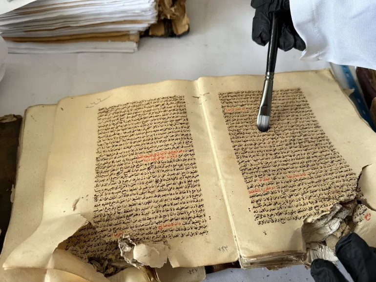 فلسطين - غزة- مخطوطات أثرية نادرة تم انتشالها من تحت أنقاض دائرة مخطوطات المسجد العمري يقوم فريق تطوعي بإسعافها للحفاظ على ما تبقّى منها.- يسرى العكلوك -الجزيرة نت 11 أبريل 2026