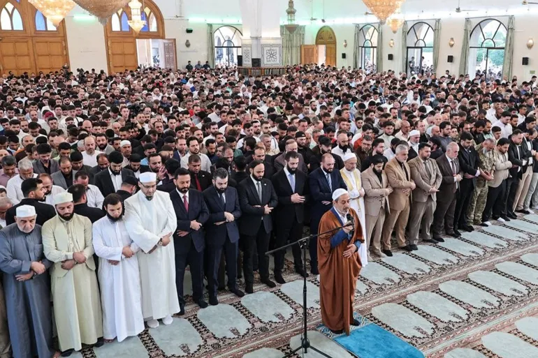 This handout photograph released by the Syrian Arab News Agency (SANA) shows Syria's President Ahmed al-Sharaa (8th from L) performing morning prayers marking the start of Eid al-Adha, the Feast of Sacrifice, at the Abdullah bin Abbas Mosque in Aleppo on May 27, 2026. (Photo by SANA / AFP) / RESTRICTED TO EDITORIAL USE - MANDATORY CREDIT "AFP PHOTO / SANA" - HANDOUT - NO MARKETING NO ADVERTISING CAMPAIGNS - DISTRIBUTED AS A SERVICE TO CLIENTS