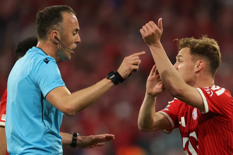Bayern Munich's German midfielder #06 Joshua Kimmich (R) demands a penalty from Portuguese referee Joao Pinheiro during the UEFA Champions League second-leg, semi-final football match between FC Bayern Munich and Paris Saint-Germain (PSG) in Munich, southern Germany on May 6, 2026.