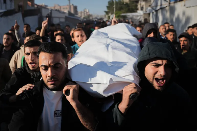 Palestinians carry the body of Naseem Al-Kalzani, who was killed in an Israeli strike, during his funeral at Nasser Hospital in Khan Younis, southern Gaza Strip, Wednesday, May 6, 2026. (AP Photo/Abdel Kareem Hana)