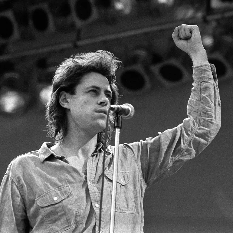 Concert organiser Bob Geldof talks on stage at Wembley Stadium, London, July 13, 1985, at the beginning of the Live Aid famine relief concert for Africa. (AP Photo/Joe Schaber)