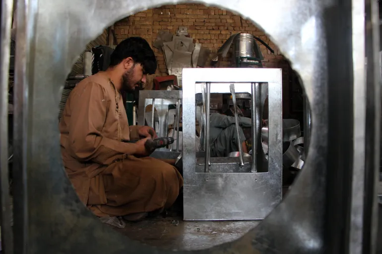 epaselect epa12949978 Afghan workers make solar powered air coolers in Kandahar, Afghanistan, 12 May 2026. Locally manufactured air conditioners in Kandahar are gaining popularity as affordable, durable alternatives to imported models. They are produced with both local and imported parts, and use less electricity. EPA/QUDRATULLAH RAZWAN
