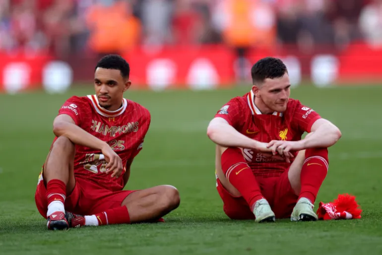 LIVERPOOL, ENGLAND - APRIL 27: Trent Alexander-Arnold and Andrew Robertson of Liverpool look on, as they celebrate the teams victory and confirmation of winning the Premier League title after the Premier League match between Liverpool FC and Tottenham Hotspur FC at Anfield on April 27, 2025 in Liverpool, England. (Photo by Carl Recine/Getty Images)