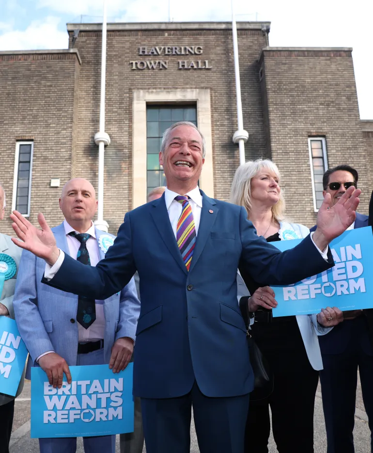 ROMFORD, ENGLAND - MAY 08: Reform UK leader Nigel Farage poses with winning councillors outside Havering Town Hall following the 2026 local election results on May 08, 2026 in Romford, England. Voters went to the polls yesterday in the local elections across England. Results counted overnight show widespread losses for the Labour Party. Several key Labour councils have surrendered their majority as Reform UK and the Liberal Democrats make significant gains. (Photo by Dan Kitwood/Getty Images)
