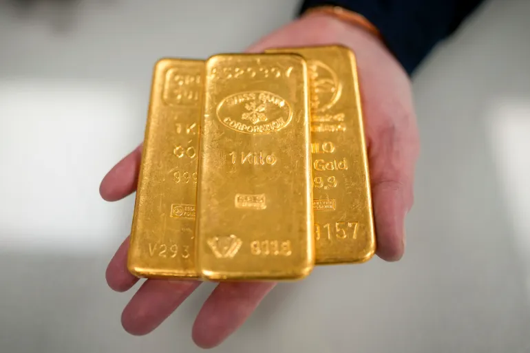 BIRMINGHAM, ENGLAND - DECEMBER 13: A jewellery quarter gold dealer poses with three 1kg gold bullion bars on December 13, 2023 in Birmingham, England. Gold prices have increased since the Ukraine War but have soared to record highs since the start of the Hamas-Israel war. Other factors are the weakening US dollar and expected rate cuts from the Federal Reserve. (Photo by Christopher Furlong/Getty Images)