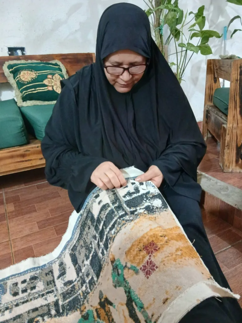 تقوم مطرزة فلسطينية بتطريز لوحة "مستشفى الشفاء" في مخيم عين الحلوة للاجئين، لبنان (بإذن من متحف فلسطين بالولايات المتحدة الأمريكية)