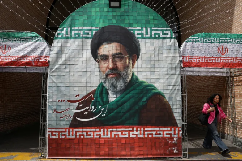 FILE PHOTO: A woman walks next to a banner with a picture of Iran's new Supreme Leader Mojtaba Khamenei in Tehran, Iran, May 8, 2026. Majid Asgaripour/WANA (West Asia News Agency) via REUTERS ATTENTION EDITORS - THIS PICTURE WAS PROVIDED BY A THIRD PARTY/File Photo