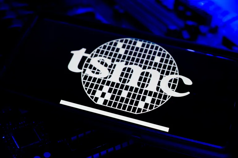 Los Angeles, California - August 3 2025: TSMC Taiwan Semiconductor Company Logo On Mobile Screen With CPU Motherboard Card Computer Chips Circuit Technology Background