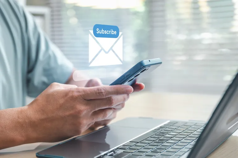 Newsletter signup concept showing a user subscribing via smartphone and laptop. Represents email marketing, digital engagement, lead generation, call-to-action strategy, and online communication.