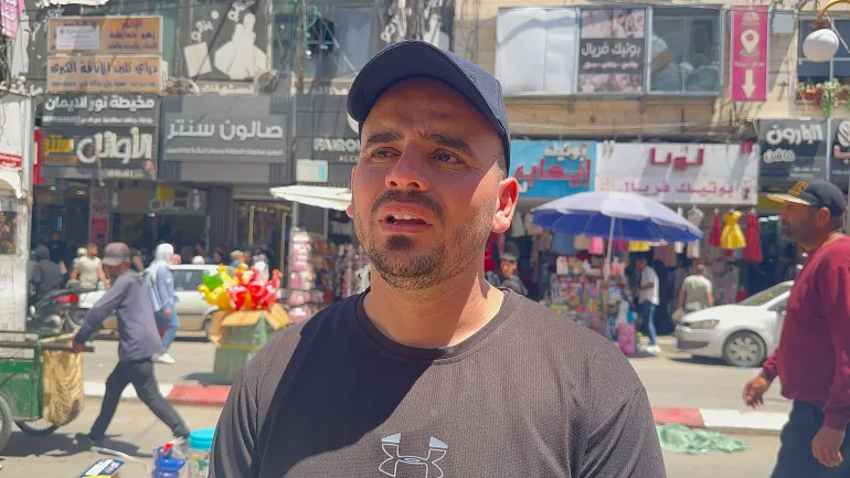 صورة ٢/ فاطمة محمود الجزيرة نت جنين فلسطين/ عدي الغول يعمل على بسطة العاب اطفال في سوق جنين يقول أن الإقبال ضعيف جداً مقارنة بالسنوات السابقة