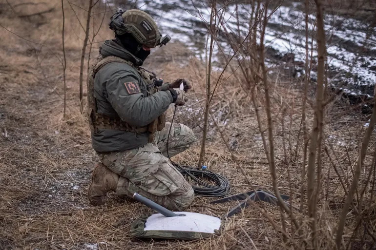 A Ukrainian serviceman of 47th brigade prepares a Starlink satellite internet systems at his positions at a front line, amid Russia's attack on Ukraine, near the town of Avdiivka, recently captured by Russian troops in Donetsk region, Ukraine February 20, 2024. REUTERS/Inna Varenytsia