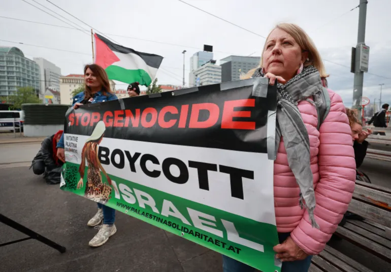 Activists hold a banner reading "Stop Genocide-Boycott Israel" to protest against the participation of Israel ahead the first semifinal of the Eurovision Song Contest, Vienna, Austria, on May 12, 2026. (Photo by Radek MICA / AFP)