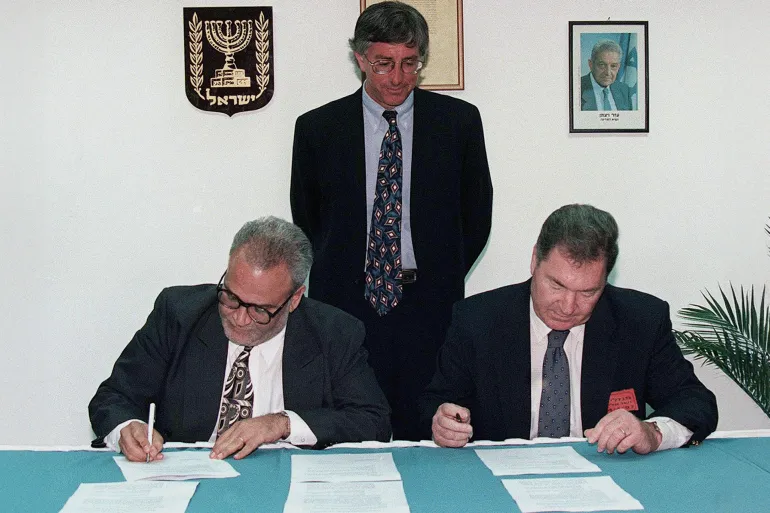 صائب عريقات United States' special envoy Dennis Ross looks on as Saeb Erekat (L), the chief Palestinian negotiator, and Dan Shomron, the chief Israeli negotiator, initial the documents that bring to a conclusion the long-delayed and overdue Israeli troop redeployment in the West Bank city of Hebron. Palestinian President Arafat and Israeli Prime Minister Netanyahu shook hands on the deal, and now both sides will take the agreement to their respective cabinets for approval. The troop redeployment will take place within ten days. MIDEAST
