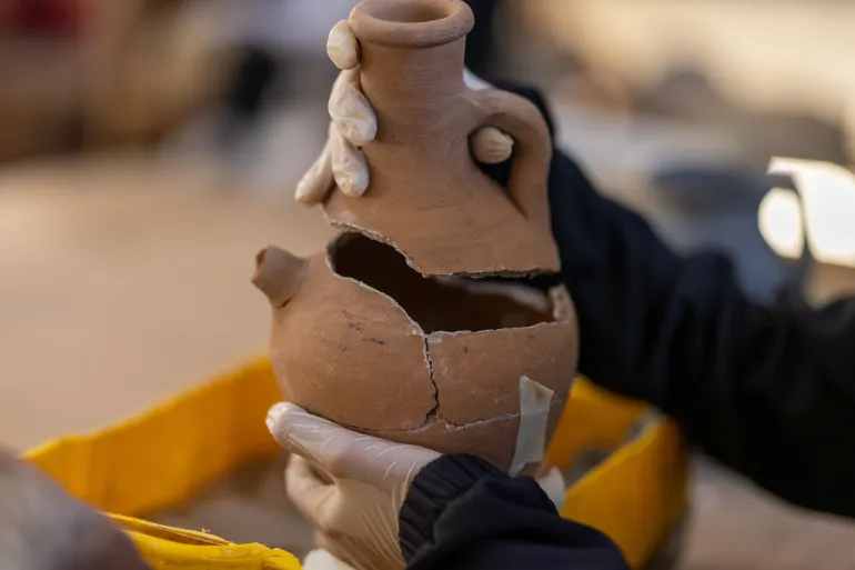 “Guardians of Heritage” work to protect Palestinian cultural heritage in the midst of war- - KHAN YUNIS, GAZA, PALESTINE - JUNE 22: A girl works on repairing a clay pot as the “Guardians of Heritage” team continues its work of collecting, documenting, and preserving historical and cultural artifacts belonging to Palestine for future generations, despite ongoing Israeli attacks in Khan Yunis, Gaza, Palestine, on June 22, 2026.