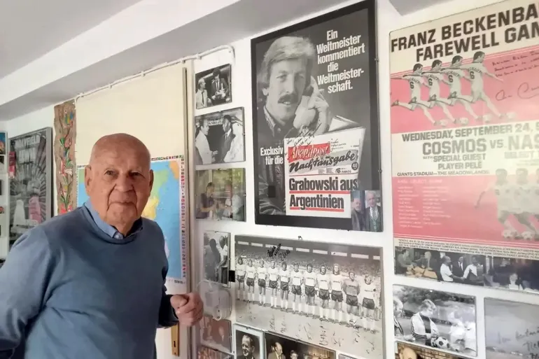 ***داخلية*** قصة صحفي ألماني لم يغِب عن تاريخ كأس العالم Daheim in Heusenstamm: Hartmut Scherzer in seinem Büro vor dem WM-Plakat mit Jürgen Grabowski. © Holger Appel