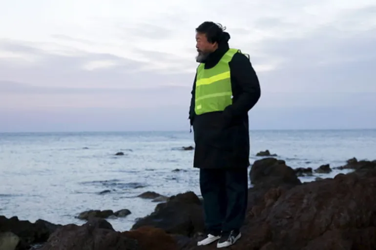 Chinese artist Ai Weiwei stands at a beach where refugees and migrants arrive daily on the Greek island of Lesbos [REUTERS]
