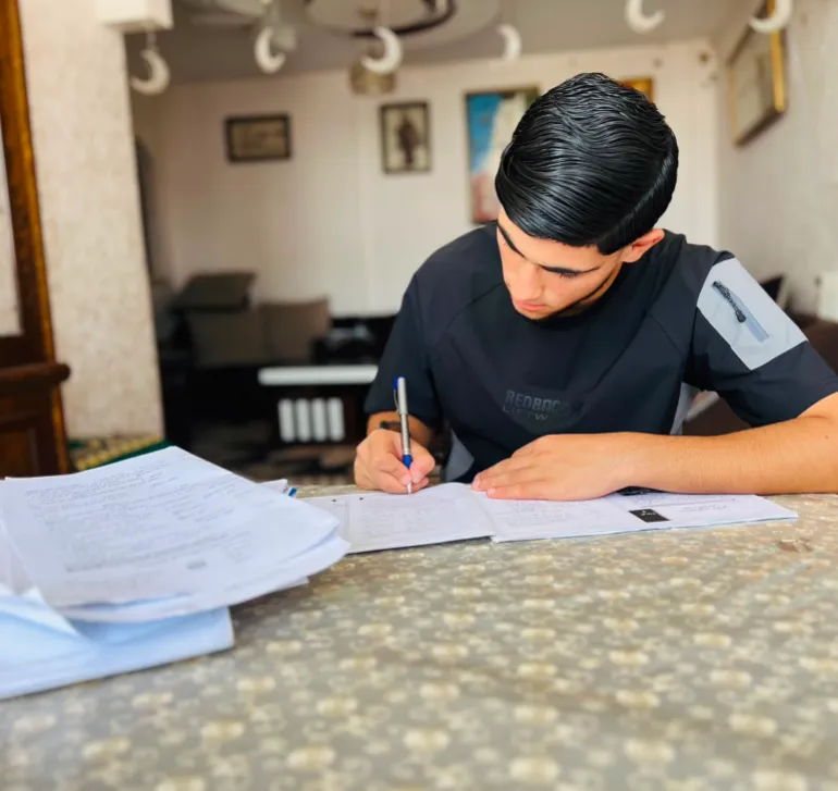 4- فلسطين- غزة- خاص بالجزيرة نت- 10 يونيو 2026- طالب الثانوية العامة عبد الله نور يستعد للتقدم للامتحانات الإلكترونية عن بُعد عبر هاتف جوال بجهد شخصي، في ظل انقطاع شبكات الطاقة والإنترنت.