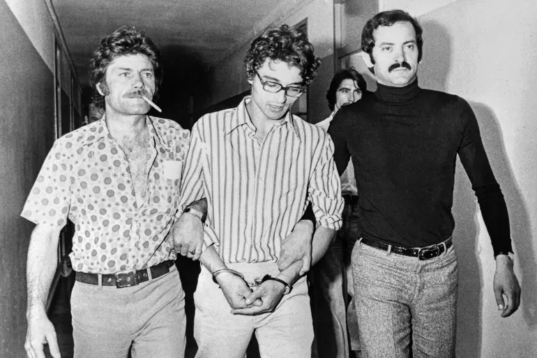 Christian Ranucci (C), 22, shown in a photo dated 06 June 1974 being escorted by police officials in Marseille after he confessed to the murder of Marie Dolores Rambla, following a fifteen-hour interrogation. Ranucci was condemned to death and executed 28 July 1976. (Photo by AFP)