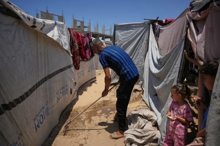 Iman Mansour bathes her son, Mohamed Shaban, in a makeshift bathroom beside her family’s tent in Khan Younis, southern Gaza Strip, Wednesday, June 3, 2026. (AP Photo/Abdel Kareem Hana)