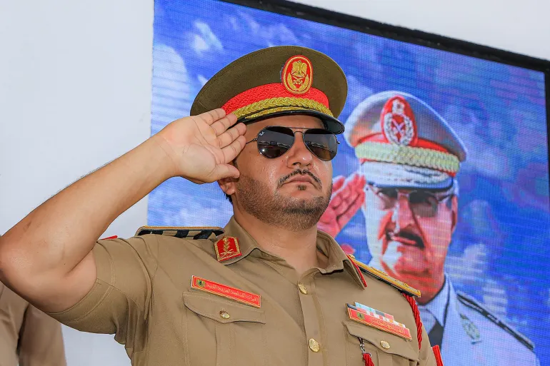 صدام حفتر A picture obtained in the FaceBook page of Libya's eastern military chief Khalifa Haftar's media office, shows his son Saddam Haftar attending a military parade in Benghazi. Libya's military strongman in the east, Khalifa Haftar, has recently appointed his youngest son as chief of land army -- the latest of household appointments in an effort to tighten the family's grip on the divided country's east. In early June, General Saddam Haftar, 33, took over as chief of staff of the land forces within the Libyan Arab Armed Forces (LAAF), the eastern-based military which his father heads. (Photo by Media office of Khalifa Haftar / AFP) / === RESTRICTED TO EDITORIAL USE - MANDATORY CREDIT "AFP PHOTO / HO /MEDIA OFFICE OF KHALIFA HAFTAR" - NO MARKETING NO ADVERTISING CAMPAIGNS - DISTRIBUTED AS A SERVICE TO CLIENTS ===