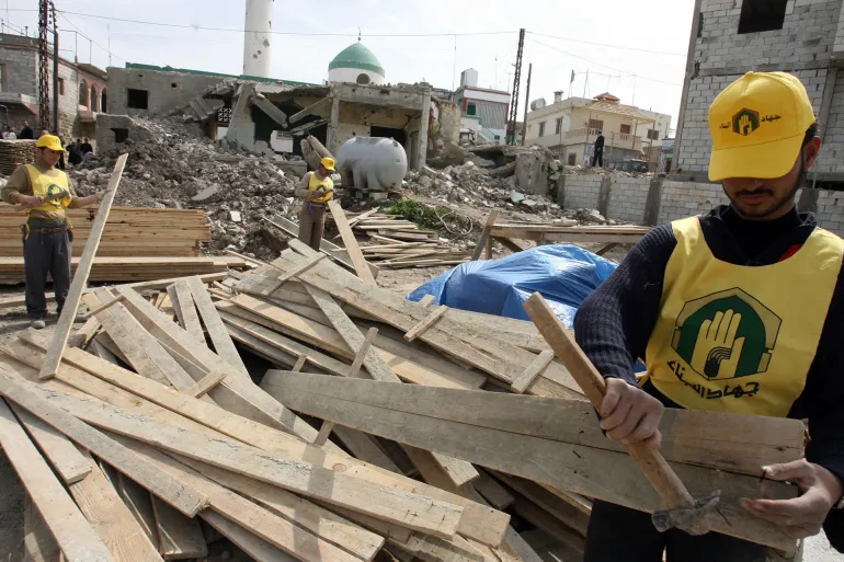 Members of Hezbollah Jihad al-Binaa, "Struggle for rebuilding", Department work on reconstructing destroyed houses in the southern Lebanese village of Srifa, 23 February 2007. For Hajj Hussein Lahham, whose house was destroyed by Israeli rockets last summer, the Jihad al-Bina construction company has been a blessing, giving him money and help to build anew. But to the United States government, this charitable arm of the Lebanese Shiite party Hezbollah is part of a terrorist group, and has been blacklisted. AFP PHOTO/RAMZI HAIDAR (Photo by RAMZI HAIDAR / AFP)