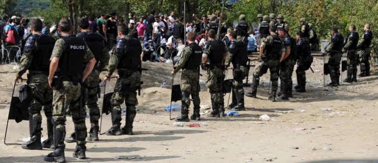 Macedonian special policemen guard the border as more than a thousand immigrants wait at the border line of Macedonia and Greece to enter Macedonia near the Gevgelija railway station August 21, 2015. Macedonian police drove back crowds of migrants and refugees trying to enter from Greece on Friday after a night spent stranded in no-man's land by an emergency decree effectively sealing the Macedonian frontier. REUTERS/Ognen Teofilovski