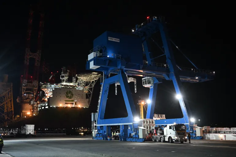 The cargo of a truck from Orano NPS (Nuclear Packages and Services), transporting MOX (Mixed Oxide Fuel composed of 8–9% plutonium and 91–92% depleted uranium), is prepared for loading onto a specialized vessel at the port of Cherbourg in northwestern France during the night of September 5 to 6, 2025 (Photo by Lou BENOIST / AFP)