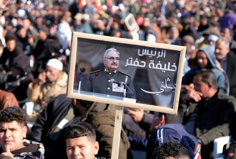A man holds a picture of commander Khalifa Haftar during Independence Day celebrations in Benghazi, Libya December 24, 2022. REUTERS/Stringer REFILE - UPDATING BYLINE (رويترز)