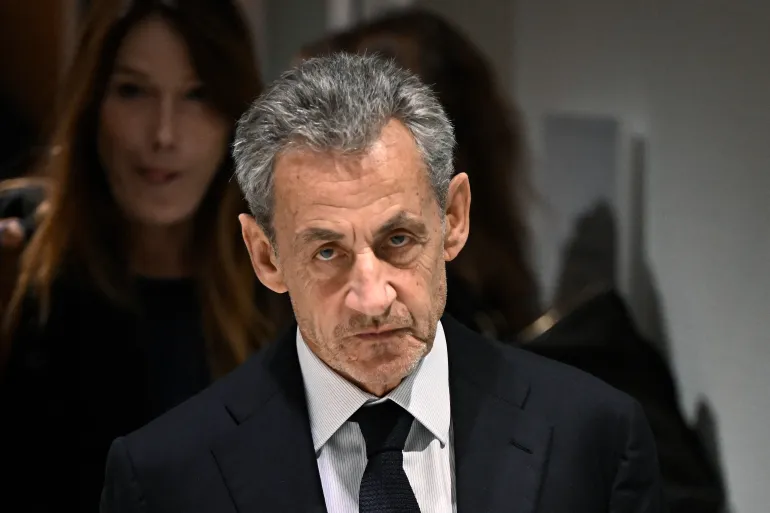 (FILES) Former French president Nicolas Sarkozy leaves in front of his wife French-Italian singer Carla Bruni after the verdict in his trial for illegal campaign financing from Libya for his successful 2007 presidential bid, at the Tribunal de Paris courthouse in Paris, on September 25, 2025.