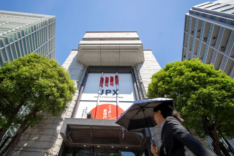 A woman walks in front of the Tokyo Stock Exchange in Tokyo on June 1, 2026. (Photo by Kazuhiro NOGI / AFP)