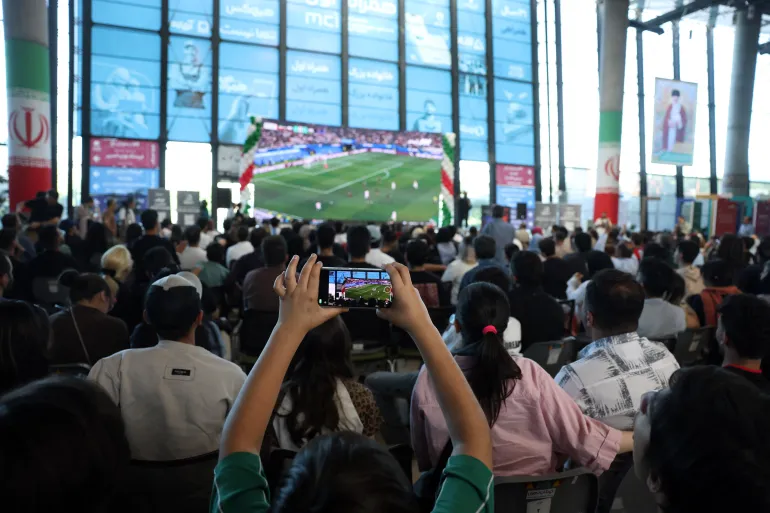 Iranians watch the 2026 World Cup football tournament match between Iran and New Zealand at Tehran Book Garden in Tehran, Iran, on June 16, 2026. (Photo by STRINGER / AFP) / ISRAEL OUT / NO ACCESS ISRAEL MEDIA/PERSIAN LANGUAGE TV STATIONS OUTSIDE IRAN / STRICTLY NO ACCESS BBC PERSIAN / VOA PERSIAN/MANOTO TV / IRAN INTERNATIONAL / RADIO FARDA -- ATTENTION EDITORS: AFP COVERS THE WAR IN THE MIDDLE EAST THROUGH ITS EXTENSIVE REGIONAL NETWORK, INCLUDING BUREAUS IN TEHRAN, JERUSALEM, AND SEVERAL NEIGHBORING COUNTRIES. SINCE THE START OF THE CONFLICT, JOURNALISTS HAVE BEEN WORKING UNDER INCREASINGLY RESTRICTIVE CONDITIONS. AUTHORITIES IN SEVERAL COUNTRIES HAVE LIMITED REPORTERS' MOVEMENTS, PHOTO AND LIVE VIDEO COVERAGE FROM SENSITIVE LOCATIONS. SOME GOVERNMENTS AND ARMED GROUPS HAVE BANNED IMAGES OF MISSILE OR DRONE STRIKES AND OTHER SECURITY-RELATED SITES.