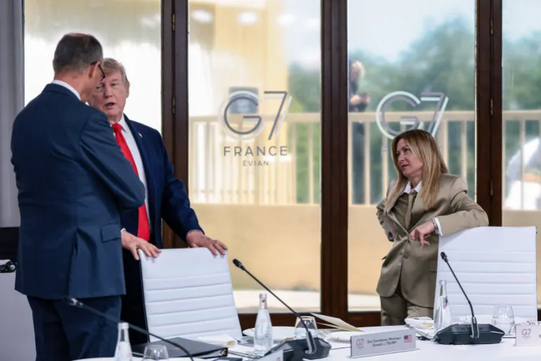 TOPSHOT - US President Donald Trump speaks with Germany's Chancellor Friedrich Merz next to Italy's Prime Minister Giorgia Meloni during a work lunch as part of the G7 summit, in Evian, eastern France, on June 16, 2026.