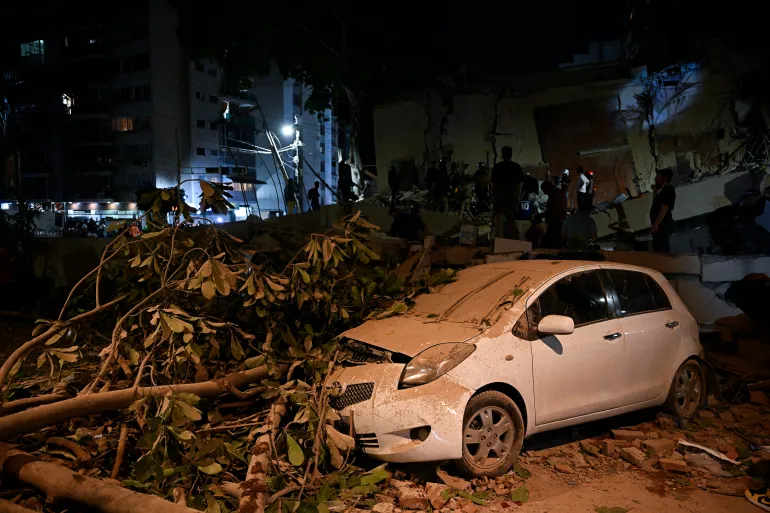 A car crushed by a fallen tree is seen following an earthquake in Caracas on June 24, 2026.