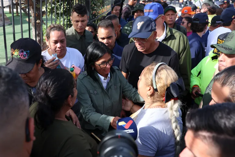 Handout picture released by the Venezuelan presidency press office showing Venezuela's interim President Delcy Rodriguez (C) and Venezuela's National Assembly President Jorge Rodriguez (C R) speaking with residents in the area strongly affected by the earthquake in La Guaira, some 35km north of Caracas on June 25, 2026.