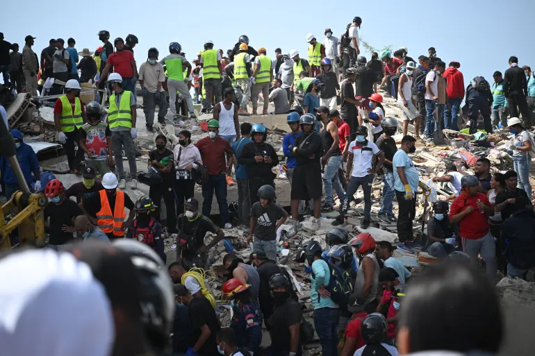 Rescuers, volunteers and residents gather on the rubble of collapsed buildings during search and recovery operations in Catia La Mar, La Guaira, Venezuela, on June 26, 2026, following deadly earthquakes.
