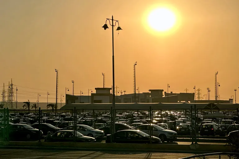 The sun sets over vehicles parked at a used car sales garage on the eastern outskirts of Cairo on October 25, 2024. (Photo by Khaled DESOUKI / AFP)
