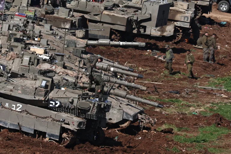 epa12806497 Israeli soldiers stand next to their tanks at a military outpost along the Israel-Lebanon border, 09 March 2026. The Israeli military stated it is conducting strikes across Lebanon targeting Hezbollah infrastructure and personnel. EPA/ATEF SAFADI
