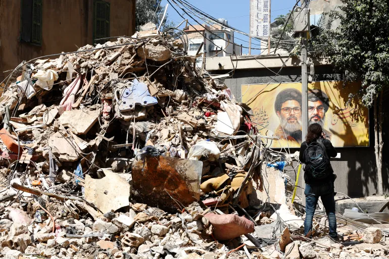 epa12938291 A woman walks a partially damaged building targeted by an Israeli strike in the Haret Hreik neighborhood, a southern suburb of Beirut, Lebanon, 07 May 2026. Israel strikes Beirut suburbs for first time since ceasefire on 17 April 2026. EPA/STRINGER