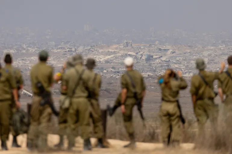 SOUTHERN ISRAEL, ISRAEL - AUGUST 13: Israeli soldiers look at destructed buildings in the Northern Gaza Strip as they are standing at a view point on the Israeli side of the border on August 13, 2025 in Southern Israel, Israel. Last week Israel's security cabinet approved Prime Minister Benjamin Netanyahu's proposal to expand IDF occupation of the Gaza Strip, including taking "complete control" of Gaza City. The planned offensive has been met with widespread condemnation by the international community, as well as hostage families, who say the move would further endanger hostages still believed to be held alive by Hamas in Gaza, as well as one million Palestinians in Gaza City, who are already facing displacement and an acute hunger crisis. (Photo by Amir Levy/Getty Images)