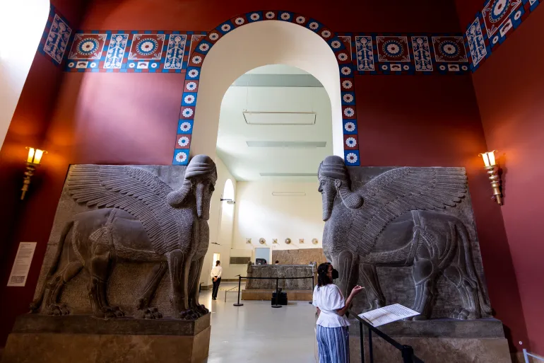 BERLIN, GERMANY - JUNE 08: Visitor stands below the entrance to the so-called “Palace Room” that is guarded by two human-headed hybrid creatures, known in Akkadian as lamas at the Pergamon Museum on June 08, 2023 in Berlin, Germany. The Pergamon will be closed to visitors for a multi-year renovation beginning October 23, 2023. Portions of the museum are scheduled to reopen by 2027. (Photo by Maja Hitij/Getty Images)