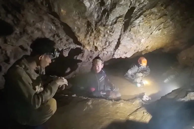 This screengrab made from handout video footage taken on May 29, 2026, and provided by Benz Norrased Palasing of Seascout Diving, shows a rescue team (C, R) about to free one (L) of seven men trapped in a semi-submerged cave in central Xaysomboun province, northeast of the capital Vientiane. A rescue team freed on May 29, one of seven men trapped inside a semi-submerged cave in Laos for more than a week, the group working at the site said. (Photo by HANDOUT / Benz Norrased Palasing / Seascout Diving / AFP) / ----EDITORS NOTE --- RESTRICTED TO EDITORIAL USE - MANDATORY CREDIT "AFP PHOTO / Benz Norrased Palasing / Seascout Diving " - NO MARKETING - NO ADVERTISING CAMPAIGNS - DISTRIBUTED AS A SERVICE TO CLIENTS - NO ARCHIVE