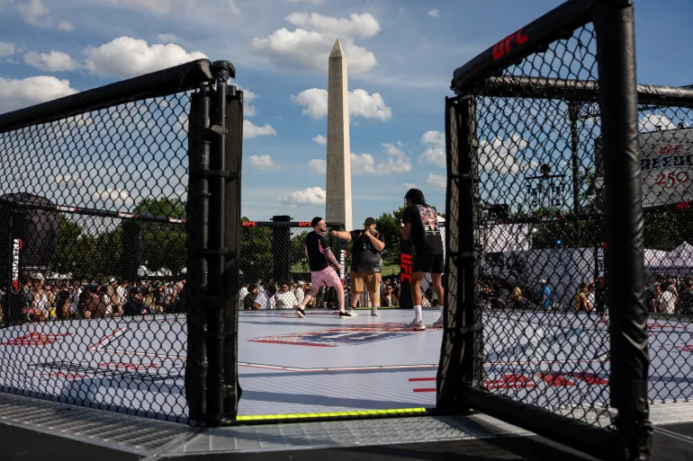 Attendees pose for a photo in an octagon in front of the Washington Monument during the UFC Freedom 250 Fan Fest at the Ellipse in Washington, D.C., U.S., June 13, 2026. REUTERS/Eric lee TPX IMAGES OF THE DAY