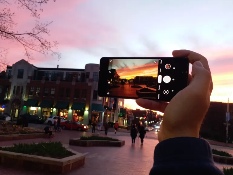 Hand holding a smartphone and taking a picture of a red sky in the evening. Bloomington, Indiana, April 10, 2019
