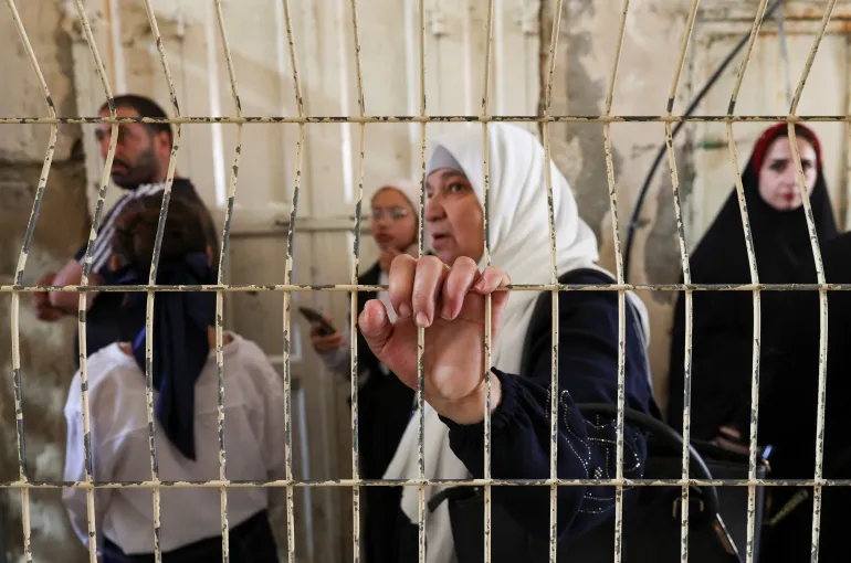 Palestinians wait at an Israeli checkpoint as they head for prayer at the Ibrahimi Mosque, also known as the Cave of Patriarchs, in the old city of Hebron, in the Israeli-occupied West Bank, June 17, 2026. REUTERS/Ammar Awad