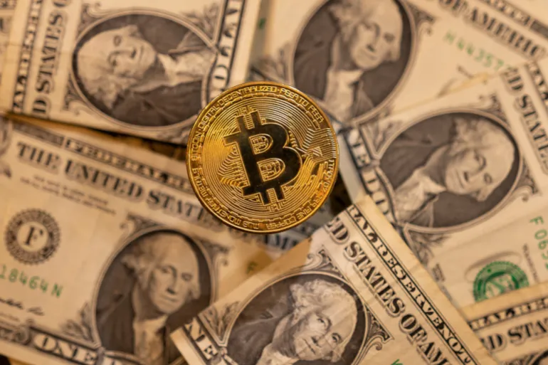 FILE PHOTO: A representation of virtual cryptocurrency Bitcoin is placed on U.S. Dollar banknotes in this illustration taken November 28, 2021. REUTERS/Dado Ruvic/Illustration/File Photo